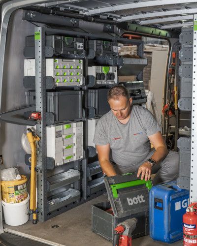 Man working in back of van - van racking with van storage boxes fitted behind him